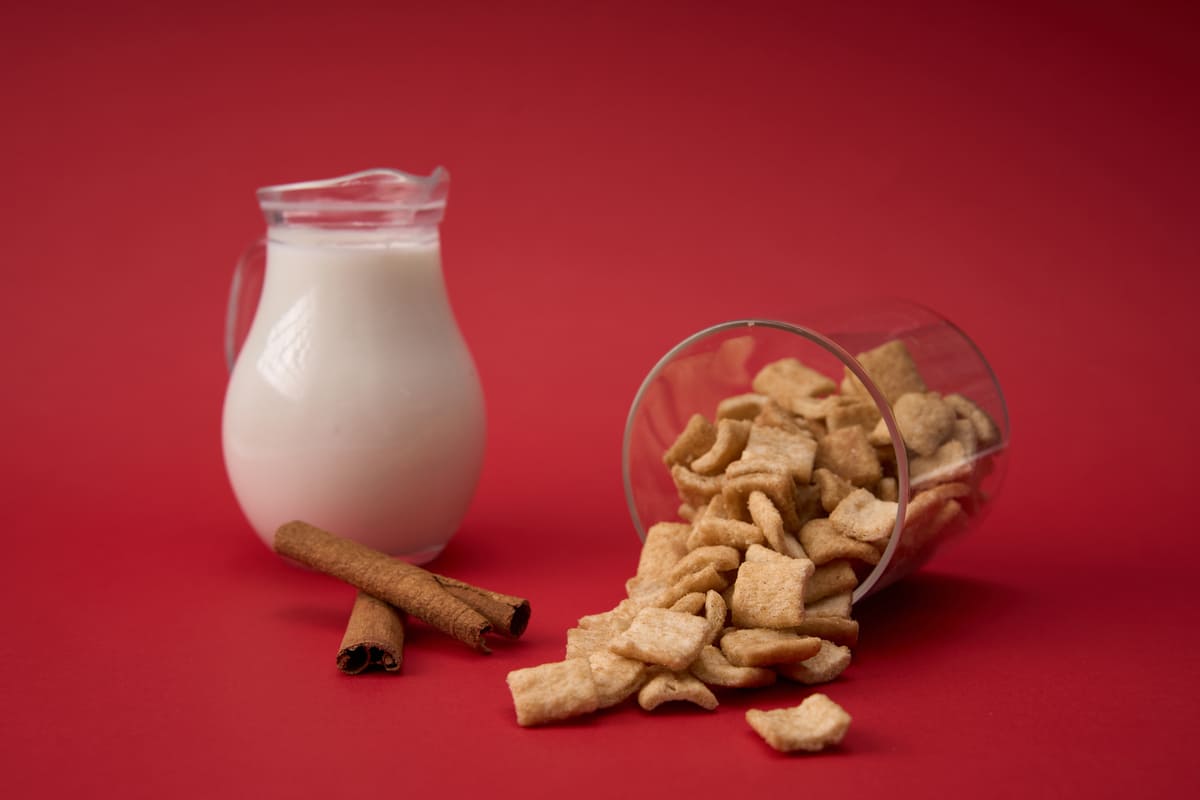 Cereale cu batoane de scortisoara si o carafa cu lapte