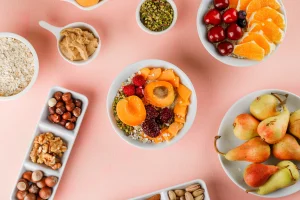 Boluri cu fulgi de ovăz, fructe proaspete, nuci și unt de arahide, reprezentând nutrienții pe care îi pot oferi snack-urile.